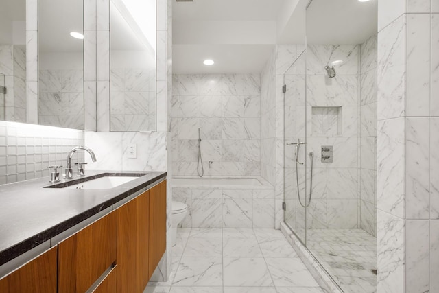 bathroom with tile walls, a washtub, toilet, a tile shower, and vanity