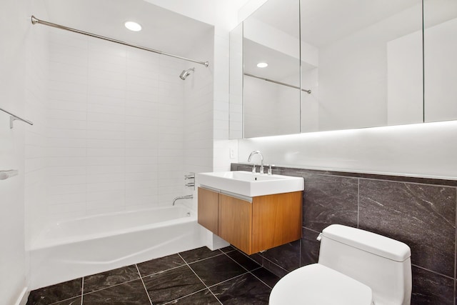 bathroom featuring shower / bath combination, toilet, tile walls, and vanity