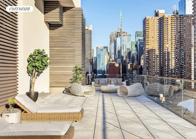 view of patio / terrace with a balcony, a view of city, and an outdoor hangout area