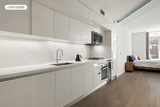 kitchen with visible vents, a sink, white cabinets, appliances with stainless steel finishes, and modern cabinets