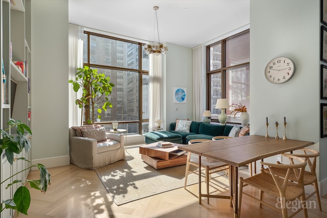 living room with expansive windows, baseboards, a healthy amount of sunlight, and a chandelier