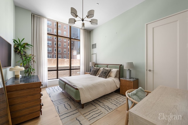 bedroom with an inviting chandelier and light wood-style floors