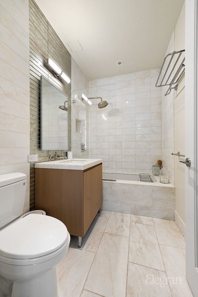 full bath featuring vanity, toilet, and tiled shower / bath