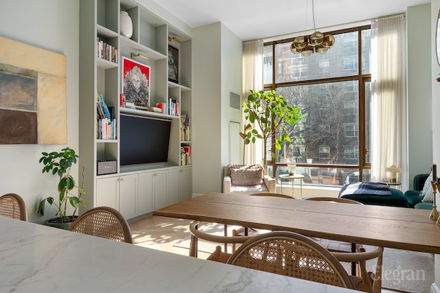 dining room featuring built in shelves and an inviting chandelier