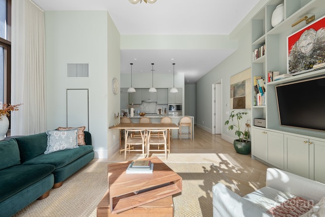 living room with baseboards and visible vents