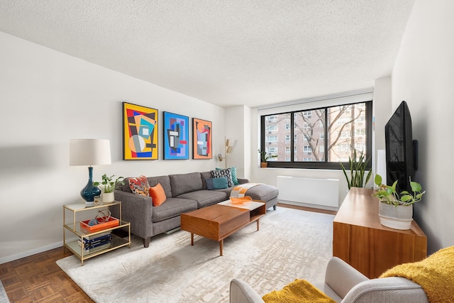 living area featuring baseboards and a textured ceiling