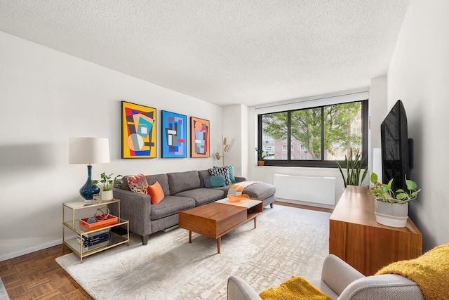 living area featuring a textured ceiling and baseboards