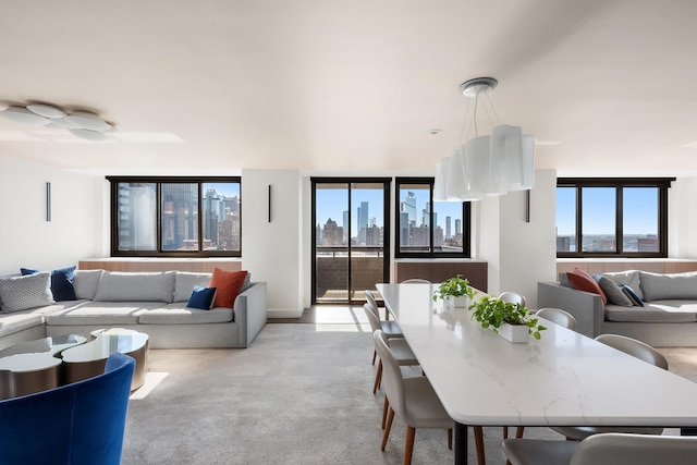 dining space with light colored carpet and a view of city