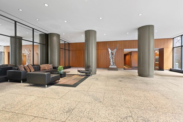 347 W 57th St Unit 3B, New York City, NY 10019 - community lobby featuring a wall of windows, wood walls, and recessed lighting