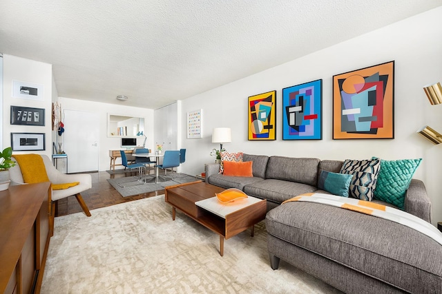living room featuring an office area and a textured ceiling
