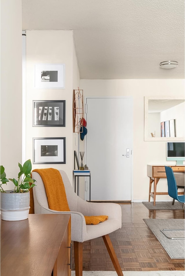 sitting room with a textured ceiling and baseboards