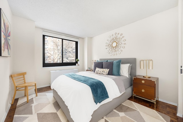 bedroom featuring baseboards and a textured ceiling