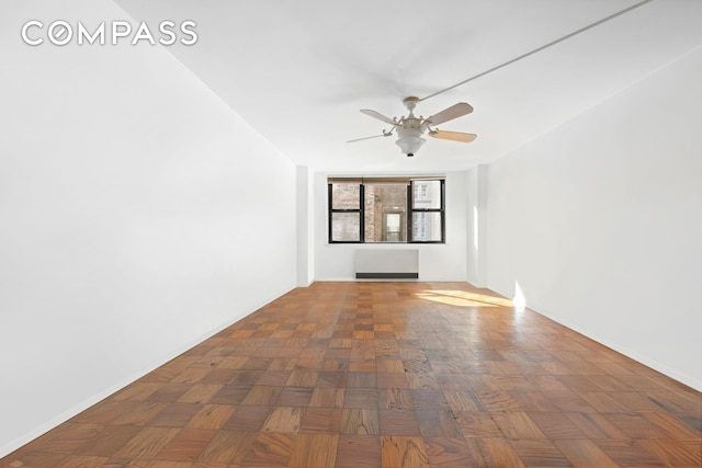 spare room with baseboards and ceiling fan