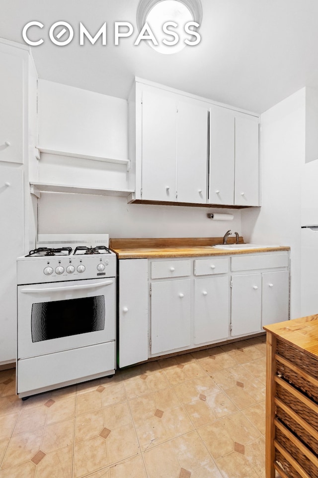 kitchen featuring white cabinetry, white appliances, light tile patterned floors, and light countertops