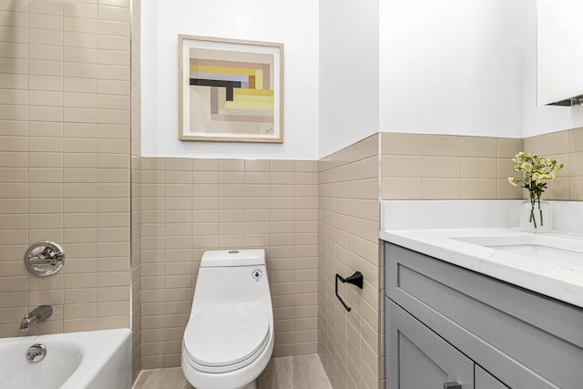 full bathroom featuring vanity, a wainscoted wall, shower / bathing tub combination, tile walls, and toilet