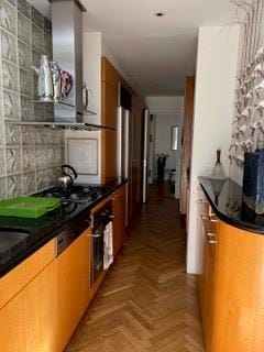 kitchen with oven, dark countertops, and brown cabinetry