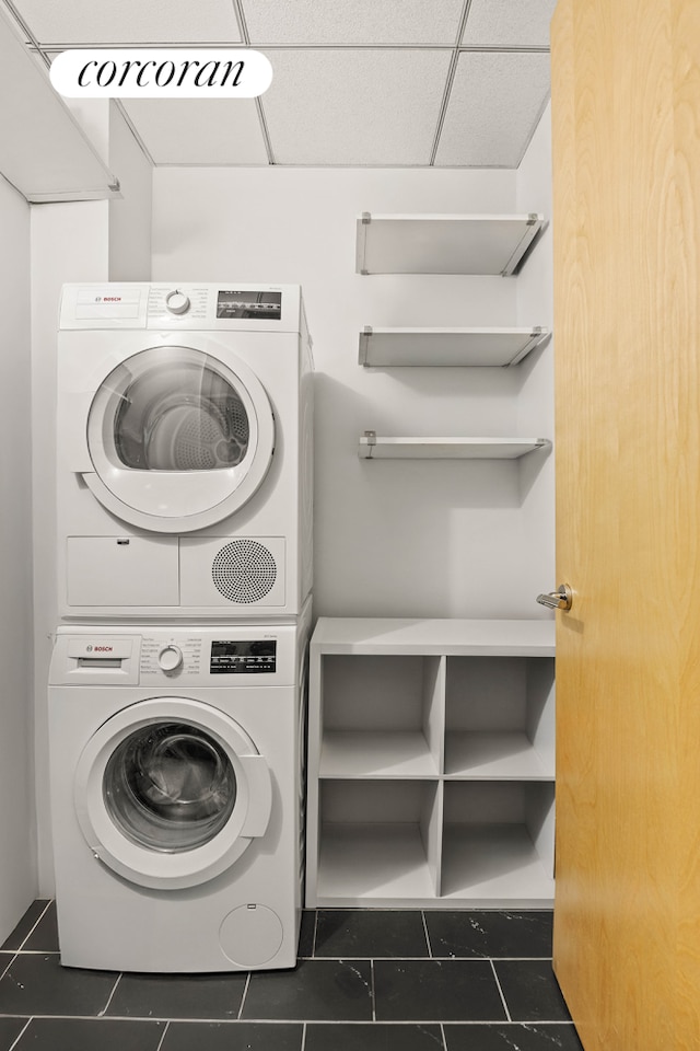 70 Washington St Unit 9G, New York City, NY 11201 - laundry area featuring stacked washer / dryer and dark tile patterned floors