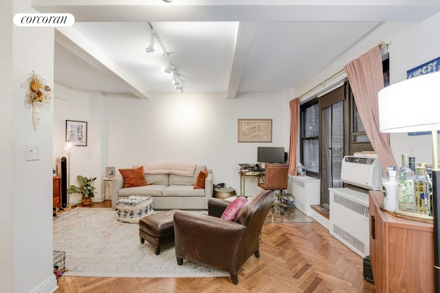 living room with beam ceiling, heating unit, visible vents, and track lighting