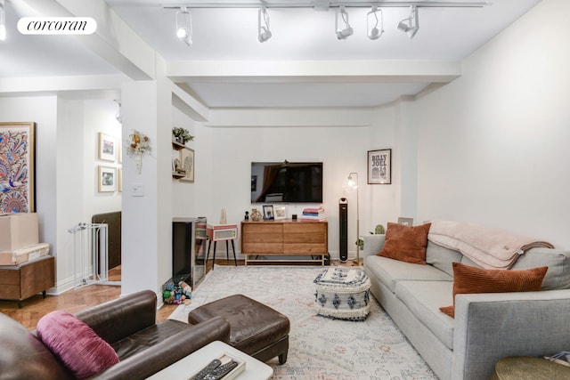 living area with visible vents, beam ceiling, wood finished floors, and baseboards