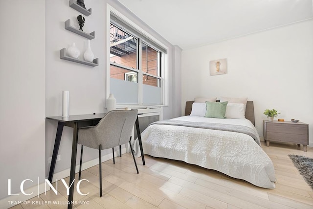 bedroom with baseboards and light wood finished floors