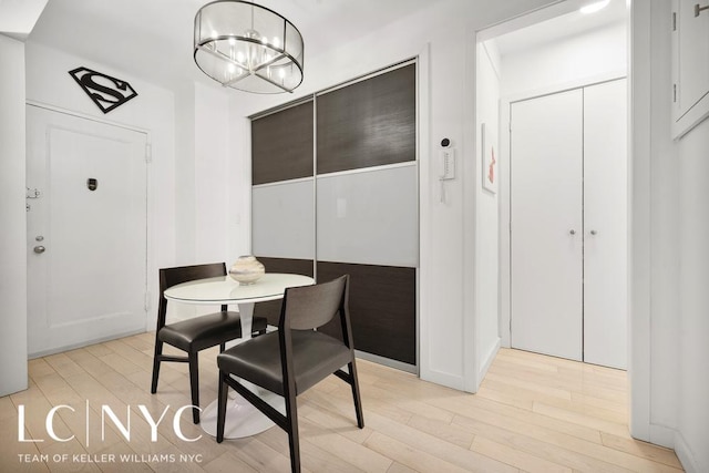 dining area featuring an inviting chandelier and light wood-style flooring