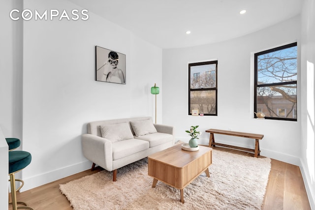 living area featuring recessed lighting, baseboards, and wood finished floors