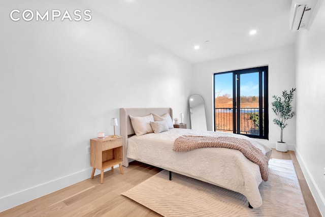 bedroom with baseboards, recessed lighting, an AC wall unit, and light wood-style floors