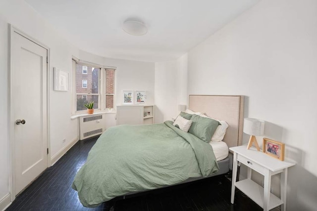 bedroom featuring radiator, baseboards, and dark wood-style flooring