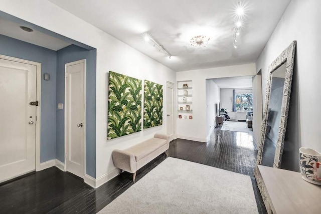 foyer entrance with baseboards, dark wood finished floors, and track lighting