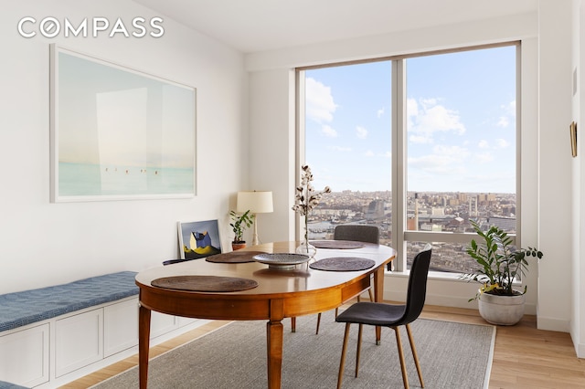 dining area featuring a city view and light wood-style flooring