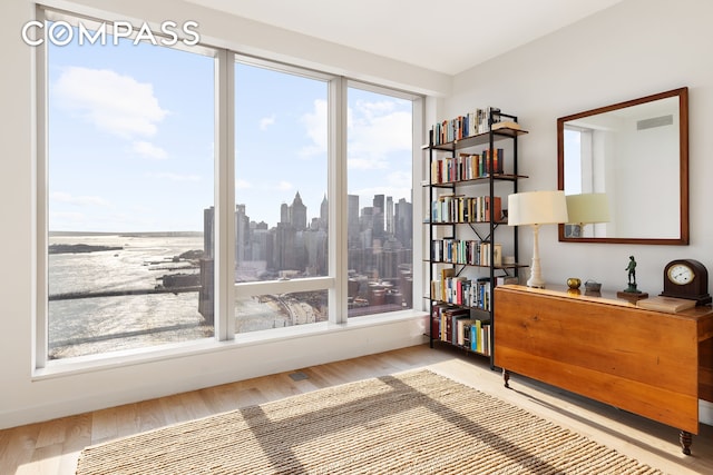 living area featuring visible vents, a city view, and wood finished floors