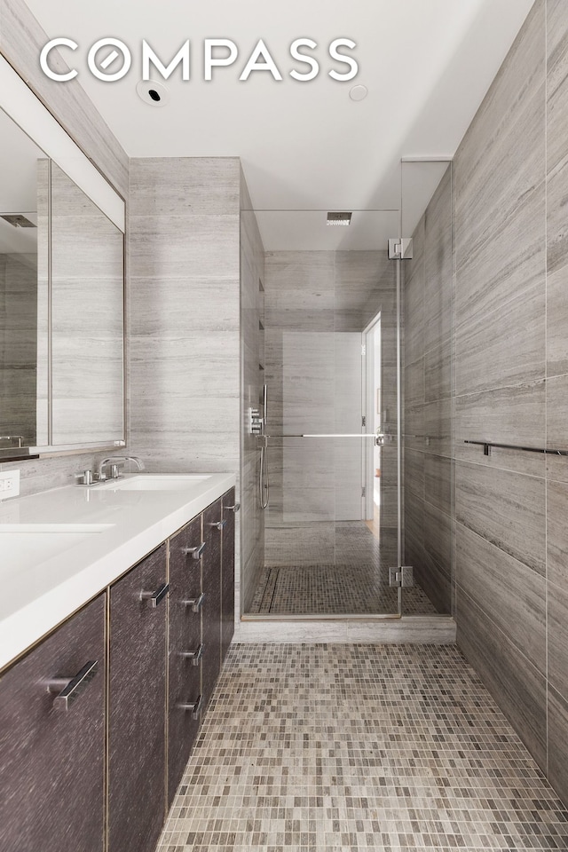 bathroom with visible vents, vanity, and a shower stall