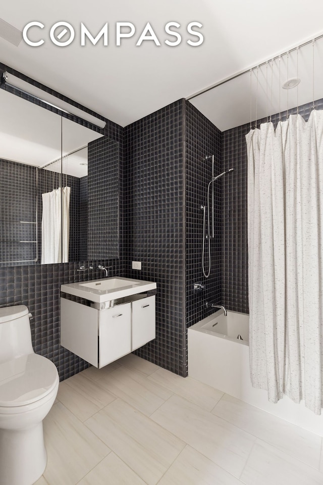 full bathroom with toilet, vanity, tile patterned floors, tile walls, and shower / bathtub combination with curtain