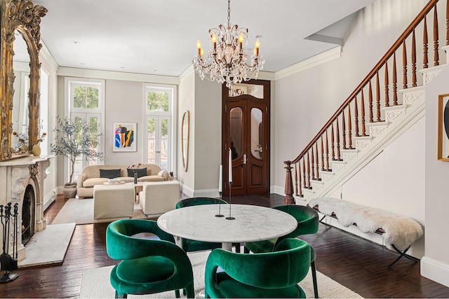 dining room with a notable chandelier, ornamental molding, wood finished floors, baseboards, and stairs