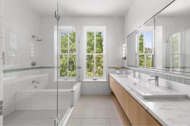 bathroom with double vanity, tiled tub, a tile shower, tile walls, and tile patterned floors