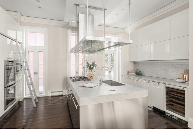 kitchen featuring beverage cooler, island exhaust hood, crown molding, and a sink