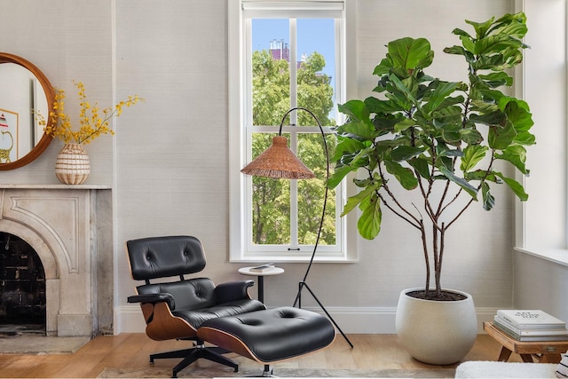 sitting room featuring plenty of natural light, a fireplace, and wood finished floors