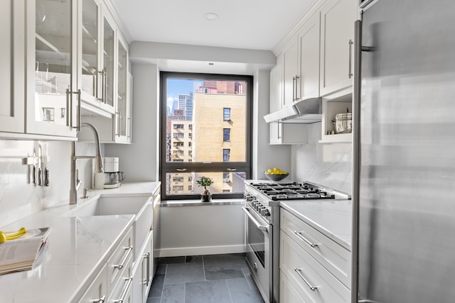 kitchen featuring tasteful backsplash, glass insert cabinets, under cabinet range hood, appliances with stainless steel finishes, and white cabinets