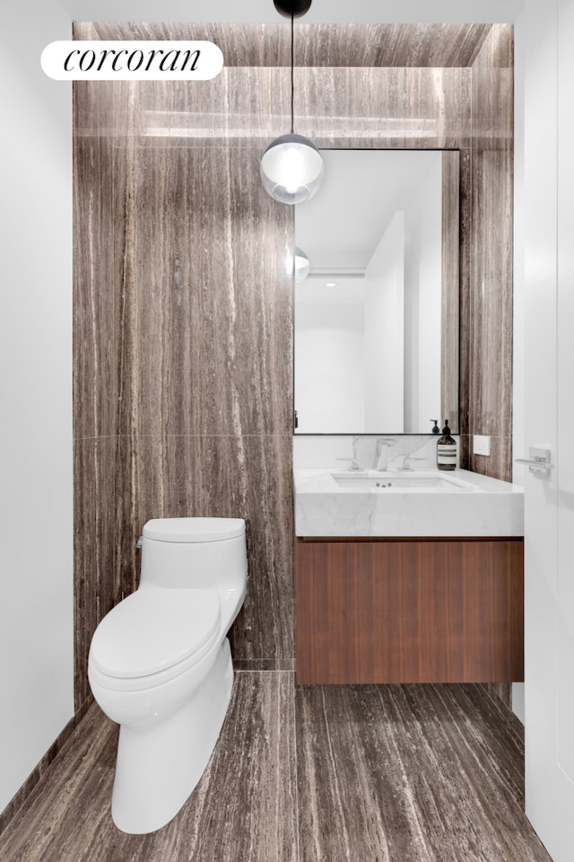 half bath featuring toilet, vanity, and wood finished floors