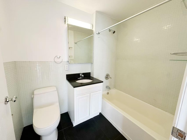 bathroom featuring tile patterned floors, tile walls, toilet, shower / tub combination, and vanity
