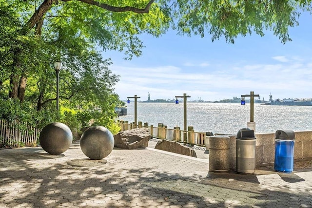 exterior space featuring fence and a water view