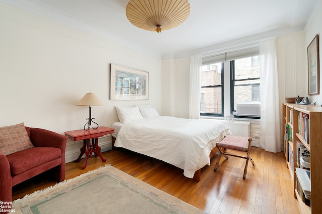 bedroom featuring crown molding and light wood-type flooring