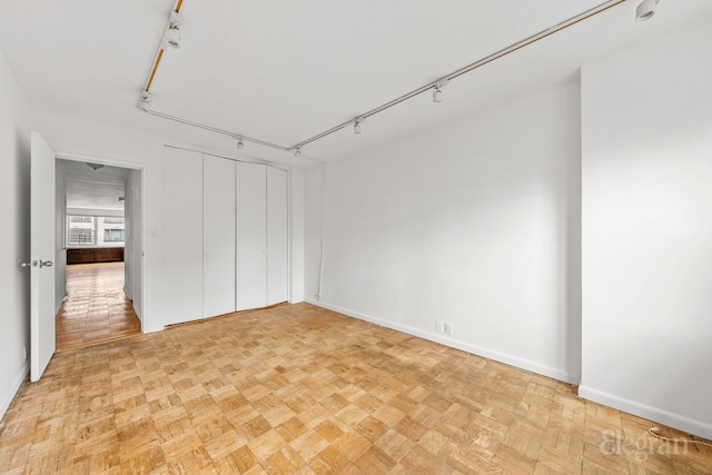 interior space featuring rail lighting and baseboards