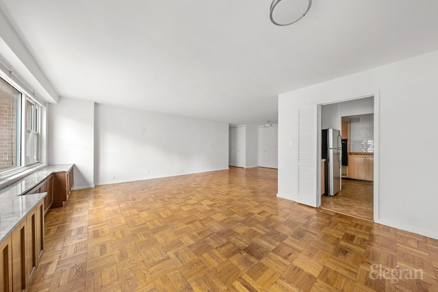 unfurnished living room featuring baseboards