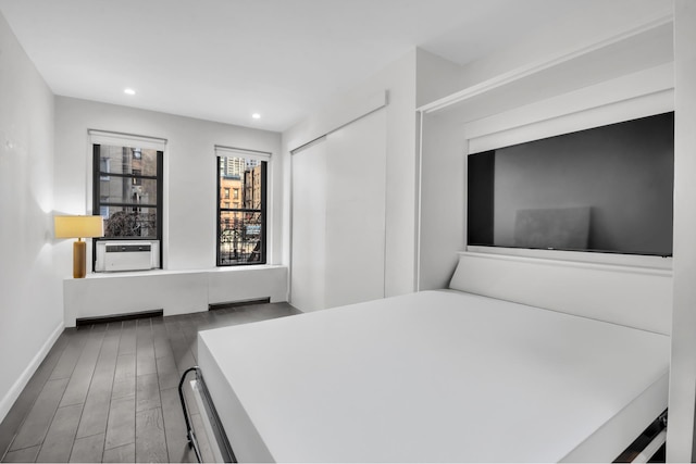 bedroom featuring baseboards, recessed lighting, cooling unit, wood finished floors, and a closet