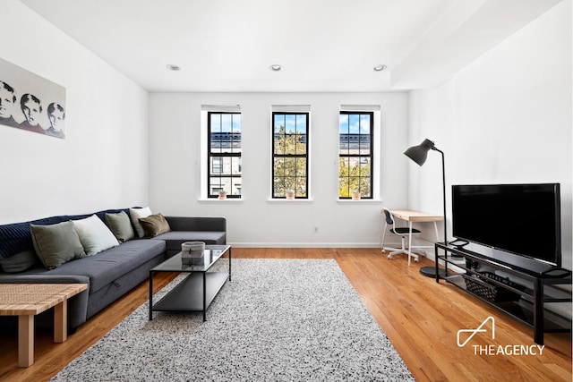 living room with recessed lighting, baseboards, plenty of natural light, and wood finished floors