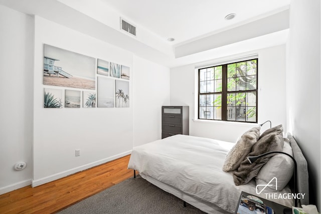 bedroom with recessed lighting, visible vents, baseboards, and wood finished floors