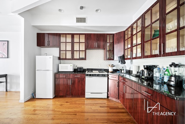 kitchen featuring white appliances, light wood finished floors, visible vents, and reddish brown cabinets