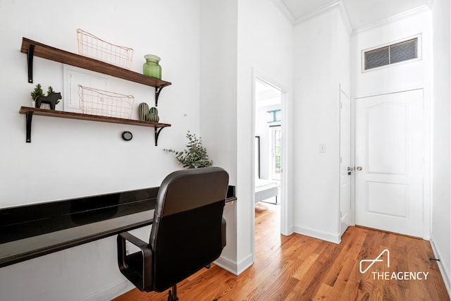 home office featuring visible vents, crown molding, light wood-type flooring, and baseboards