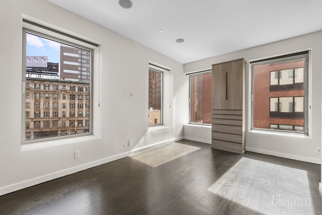 unfurnished room with dark wood finished floors, stairway, and baseboards